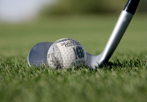 golf iron and money ball on grass