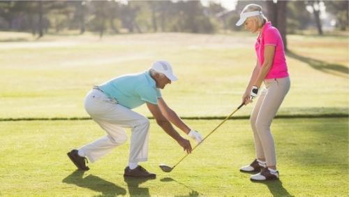 senior golfer teaching beginner