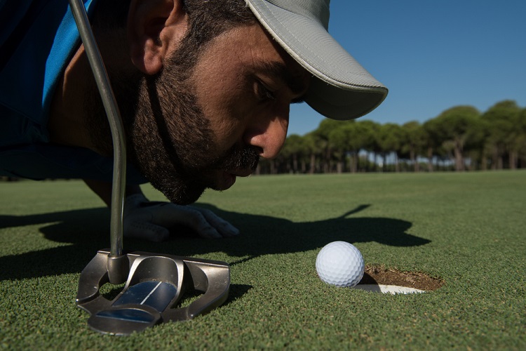 golf player blowing ball in hole