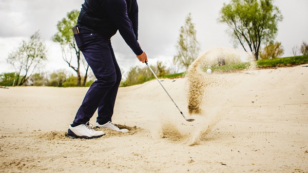 golfer's feet into the sand