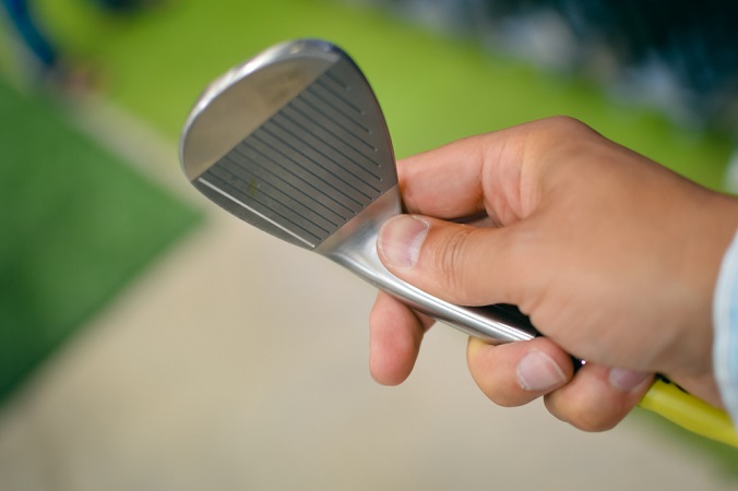 hand holding golf wedge